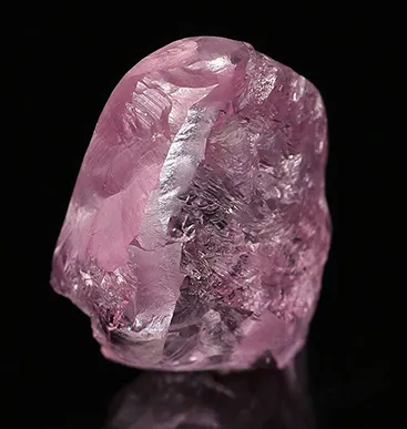 A brilliant-cut diamond on white marble